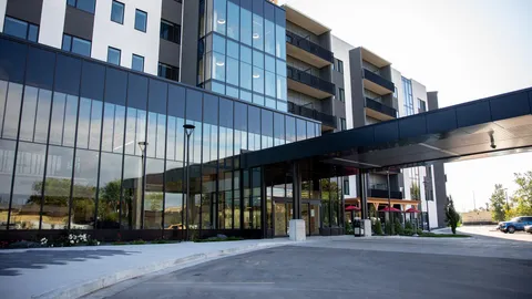 Modern multi-storey residence with glass walls and a covered entrance