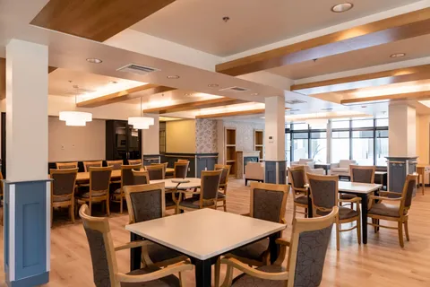 Dining room with wooden tables, upholstered chairs and ceiling beams