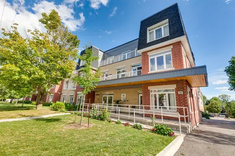 Brick residence with front porch, balconies and landscaped lawn