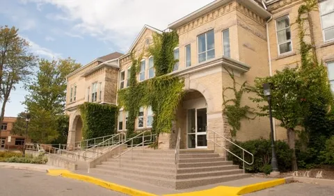 Brick building entrance with broad steps and metal railings