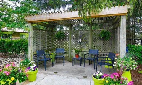 Pergola seating surrounded by flowers and greenery