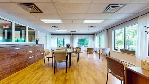 Sunny sitting area with tables and chairs beside windows