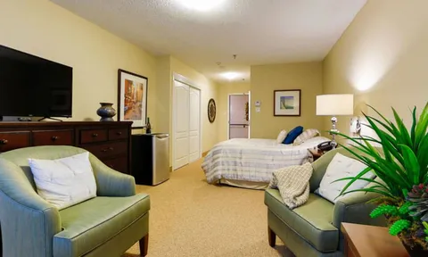Studio suite with bed, armchairs and television