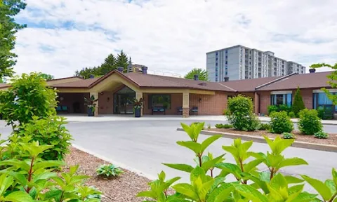 Residence entrance and driveway viewed through planting