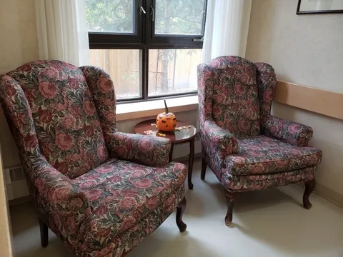 Two floral armchairs beside a window