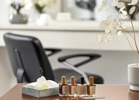 Salon counter with nail polish and a styling chair in the background.