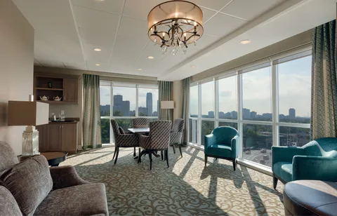 Penthouse lounge with seating beside broad city-facing windows.