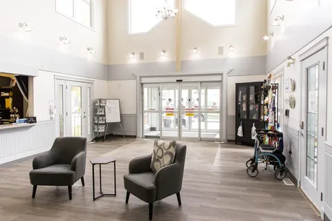 Entrance lobby with armchairs, glass doors and a reception counter