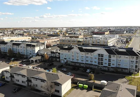 Aerial view of the residence, its covered entrance and parking area