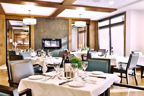Dining room with tables, chairs and a stone fireplace