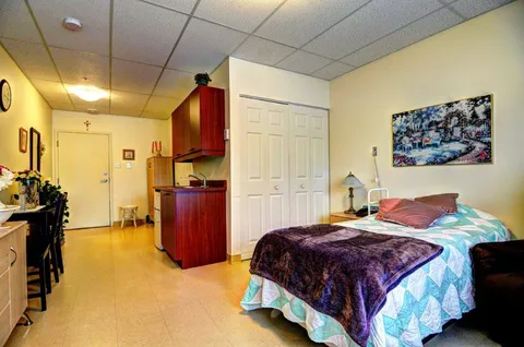 Bedroom with a bed and kitchenette.