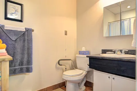 Bathroom with a sink, toilet and mirror.