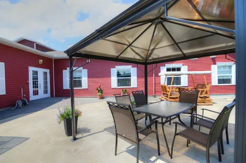 Covered patio with outdoor tables and chairs.