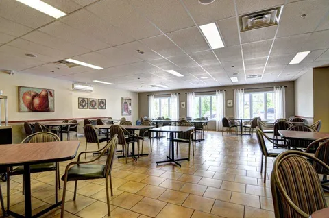 Dining room with wooden tables and chairs.