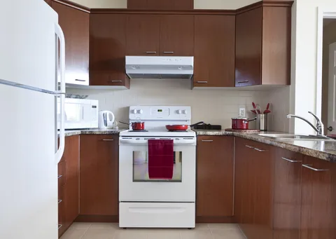 Kitchen with brown cabinets, a white stove, a refrigerator and a sink