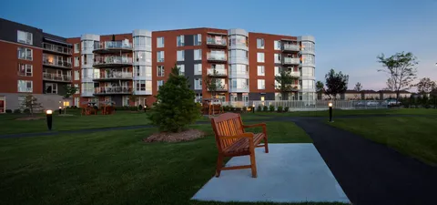 Brick residence with balconies, lawns, paved paths and benches