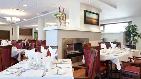 Dining tables set with white linens beside a double-sided fireplace