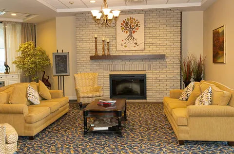 Sitting area with yellow sofas, armchairs and a brick fireplace