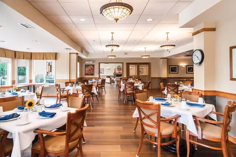 Dining room with set tables, wooden chairs and hanging lights