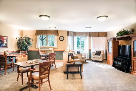 Room with tables, chairs, armchairs and a blank television