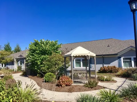 Single-storey building beside a garden and a gazebo