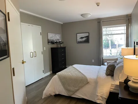 Bedroom with a bed, dresser, wardrobe and window