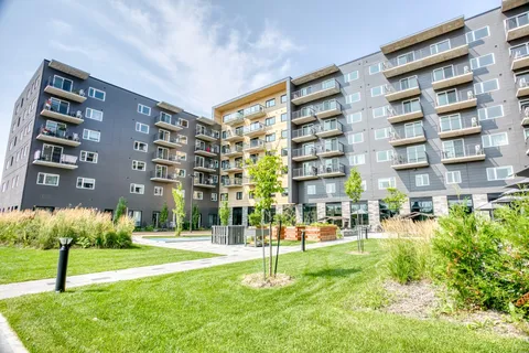 Residence buildings with balconies above a landscaped courtyard.
