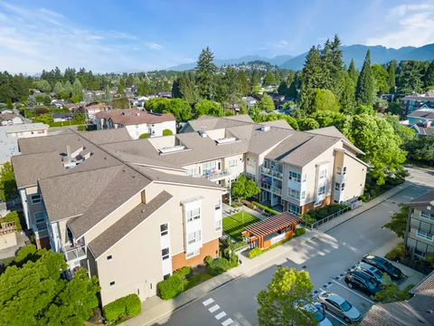 Aerial view of the residence and its entrance beside tree-lined streets