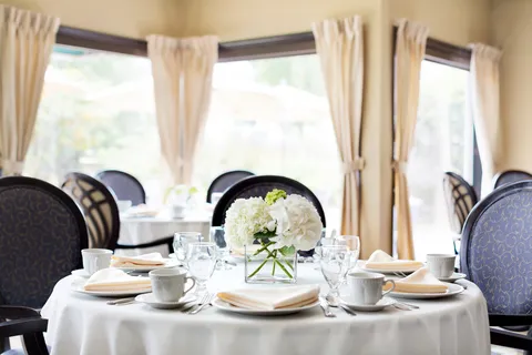Round dining table beside large windows.