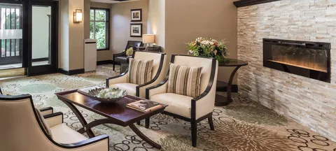 Fireside lounge with upholstered seating and stone fireplace.