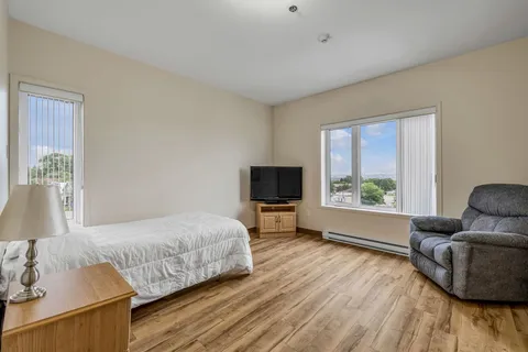 Bedroom with a single bed, bedside cabinet, recliner and television