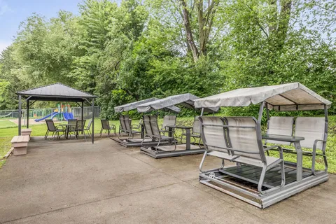Covered outdoor swings and chairs on a paved patio