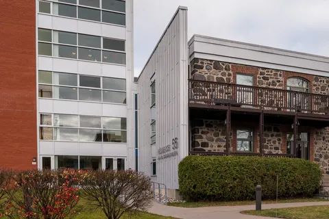 Residence exterior with brick and stone walls, windows, balconies and shrubs