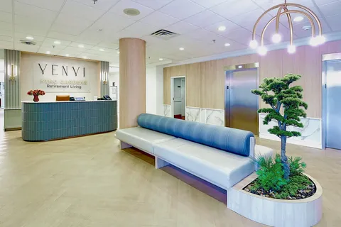 Reception lobby with a long bench, planter and counter.