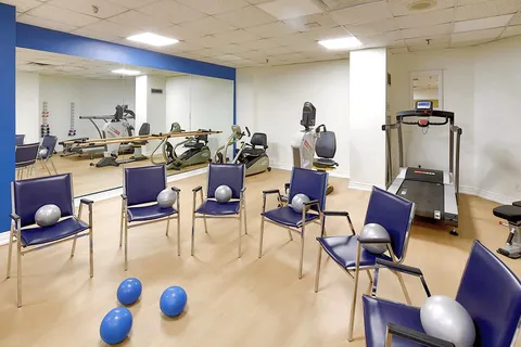 Fitness room with chairs, weights and exercise machines.