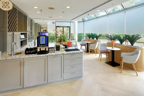 Bright bistro with a coffee counter, tables and large windows.