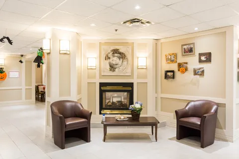 Lounge with two armchairs beside a fireplace.