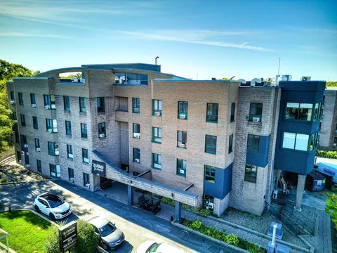 Elevated view of the residence facade and parking spaces.