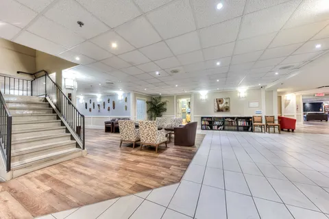 Lobby with a staircase, tiled floor and seating area.