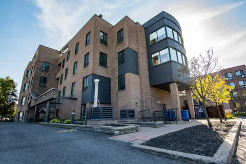 Street-level view of the brick residence and its corner windows.