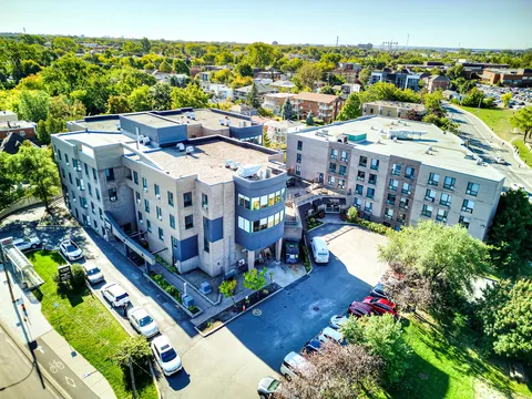 Aerial view of the residence, parking area and nearby trees.
