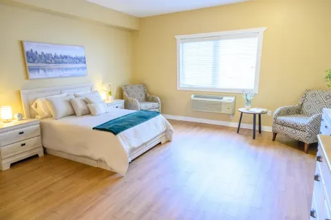 Bedroom with bed, armchair and bedside tables.