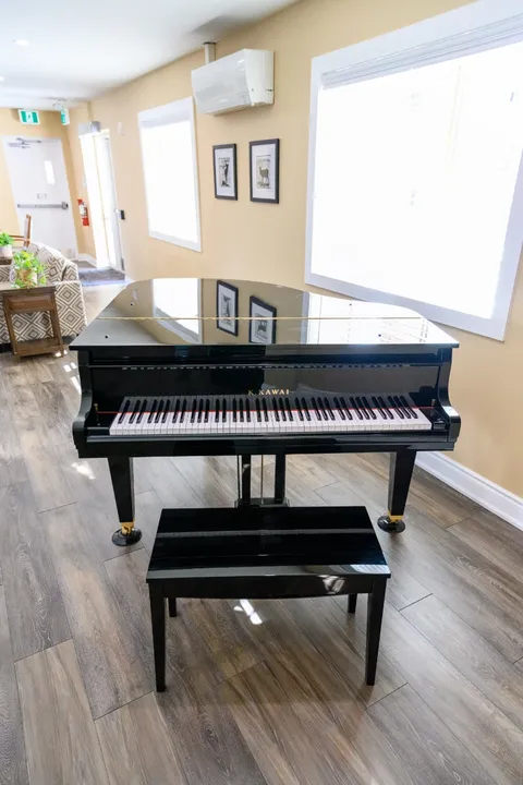 Grand piano beside a window.