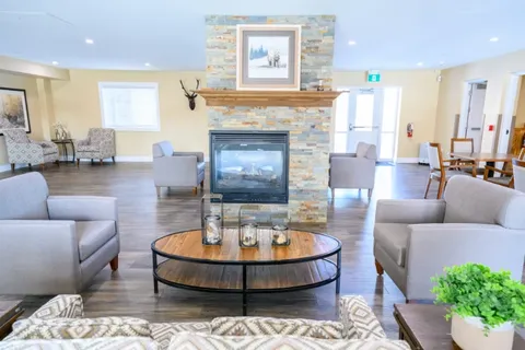 Lounge chairs and a coffee table beside a stone fireplace.