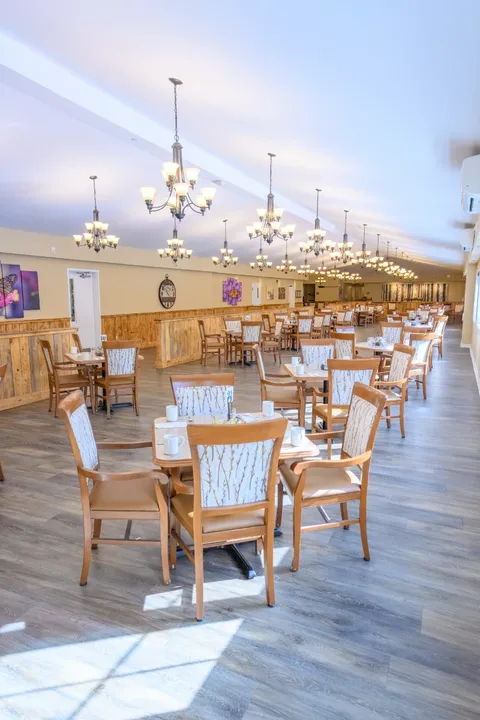 Dining room with wooden tables and pendant lights.