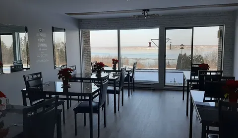 Dining room with tables beside windows overlooking the river.