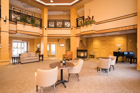 Two-storey room with armchairs, tables, a fireplace and piano