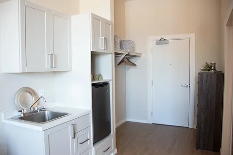Suite kitchenette with sink, cupboards and refrigerator.
