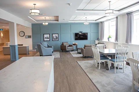 Memory-care common area with a kitchen counter and seating.