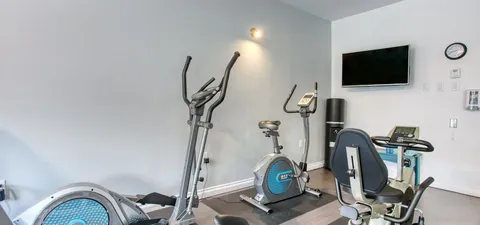 Fitness room with exercise machines and a wall-mounted television